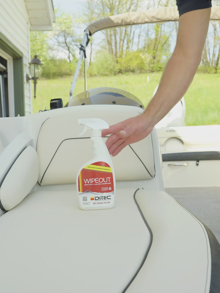 Man applying spray-on degreaser and bleach-free all purpose cleaner Wipeout from DiTEC Marine products for vinyl boat seats, boat carpets, and more.