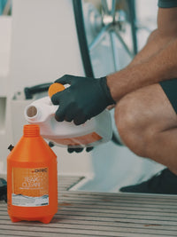 man applying eco friendly teak cleaner from ditech to boat's deck