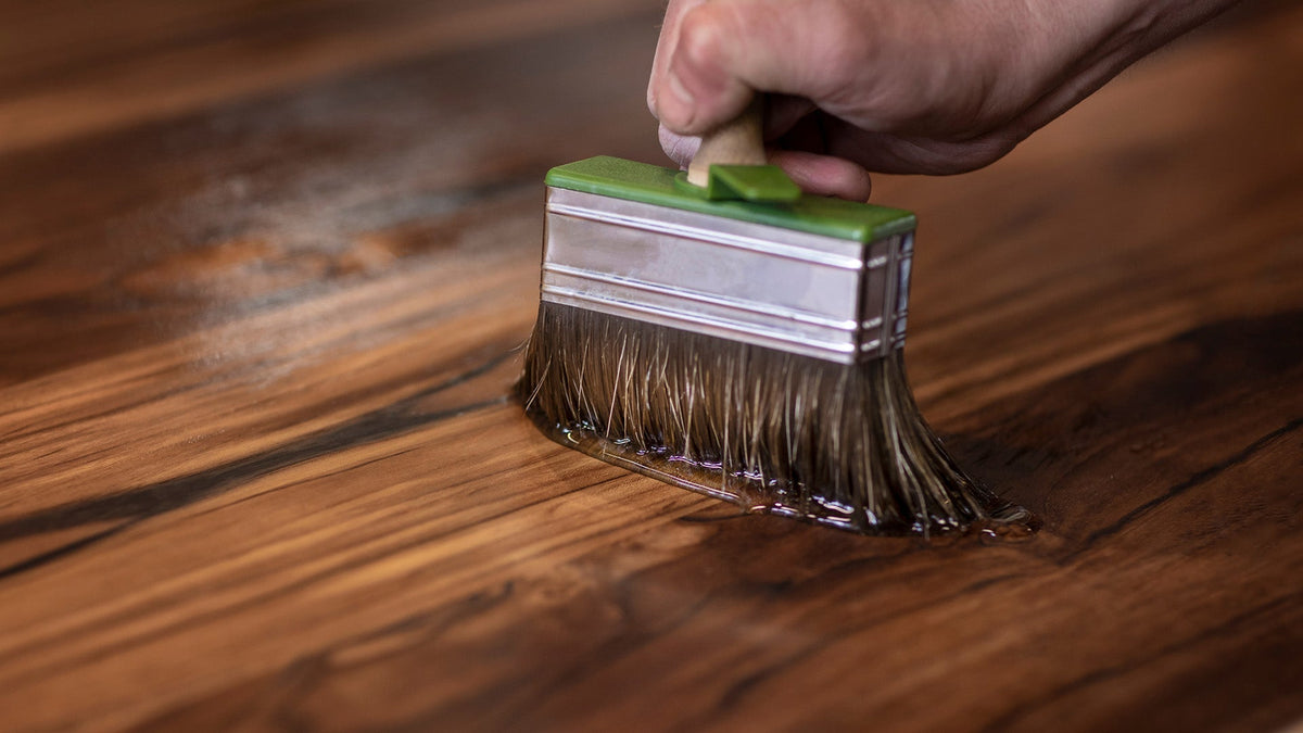 Teak oil being applied with large brush